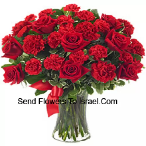 12 roses rouges et 12 oeillets rouges avec des fougères dans un vase en verre